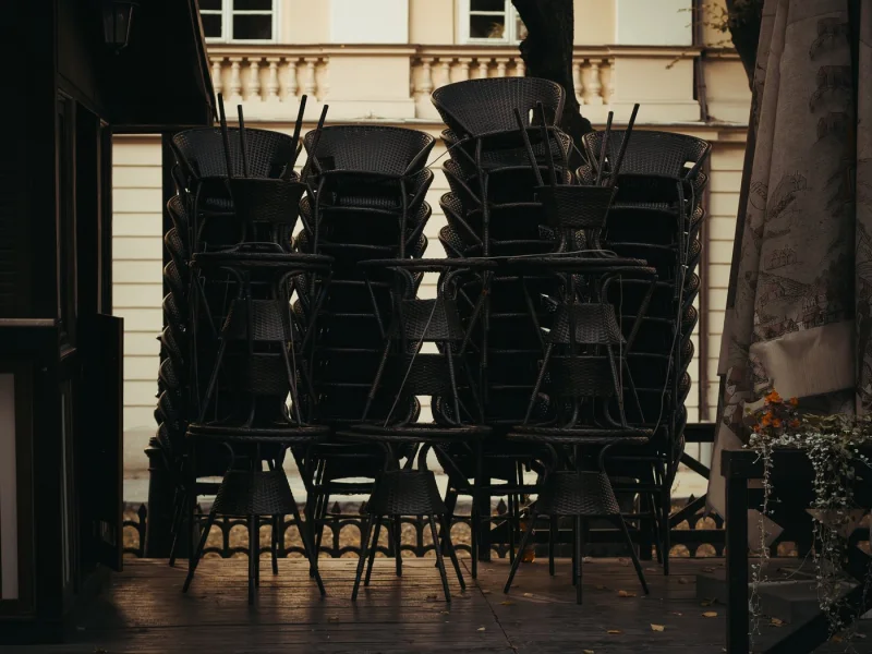 Clock behind a bar with chairs up on the tables at close