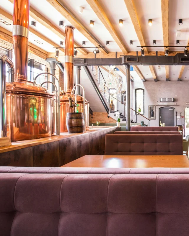 Brewery taproom with tanks and timber benches