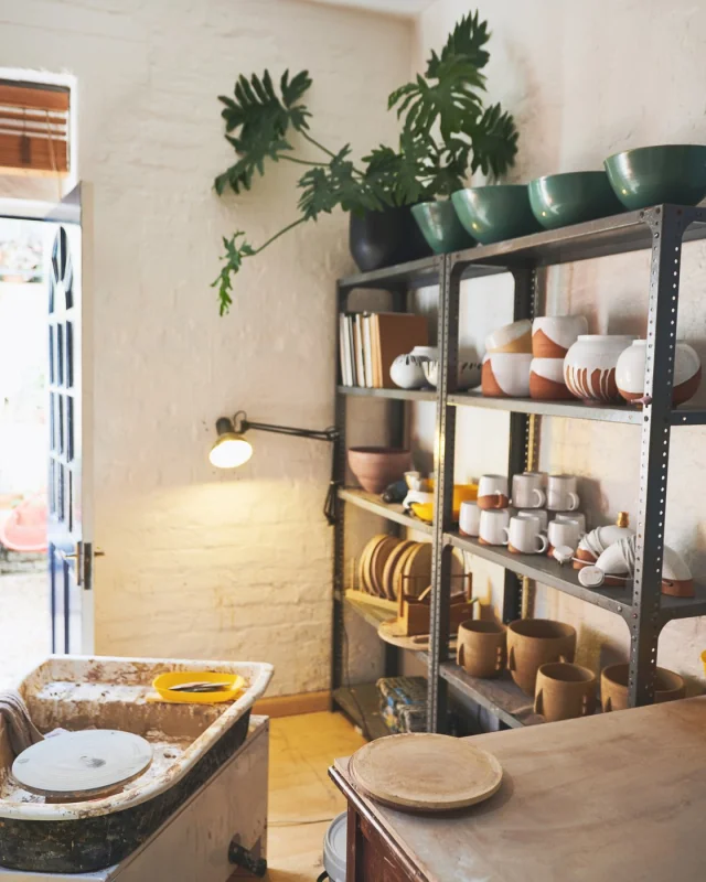 Small shop interior with stock on steel shelving by an open door