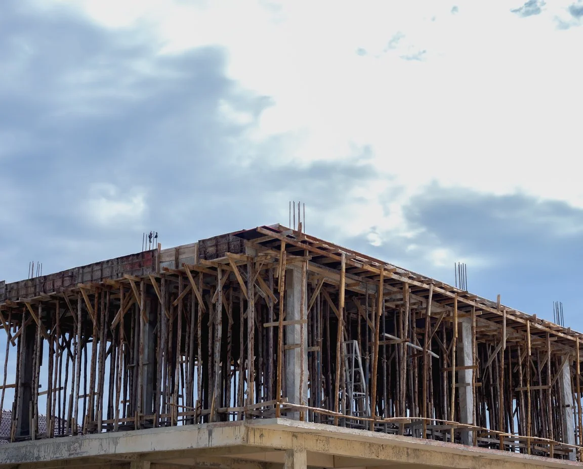 Concrete deck on timber shoring under an overcast sky, nobody on site