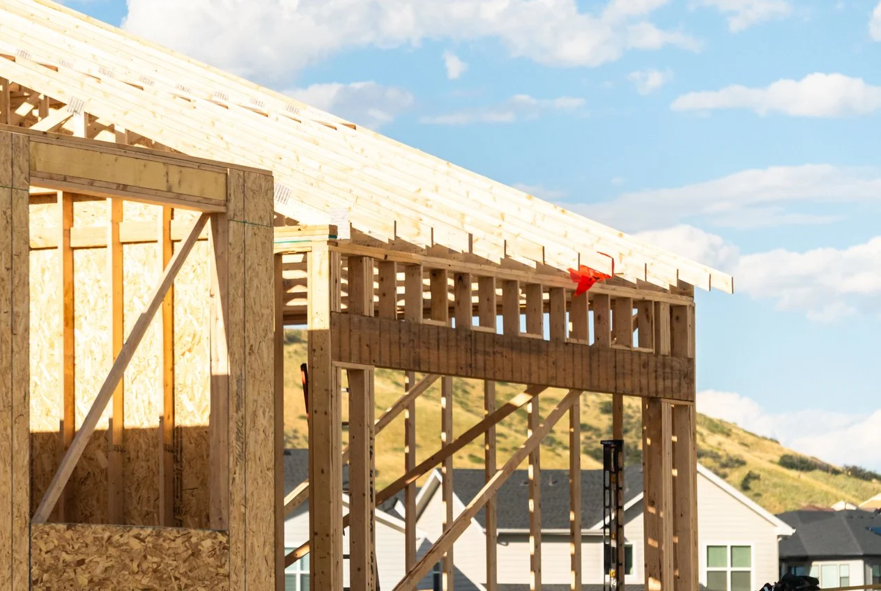 Timber-framed house under construction with the roof structure open to the sky