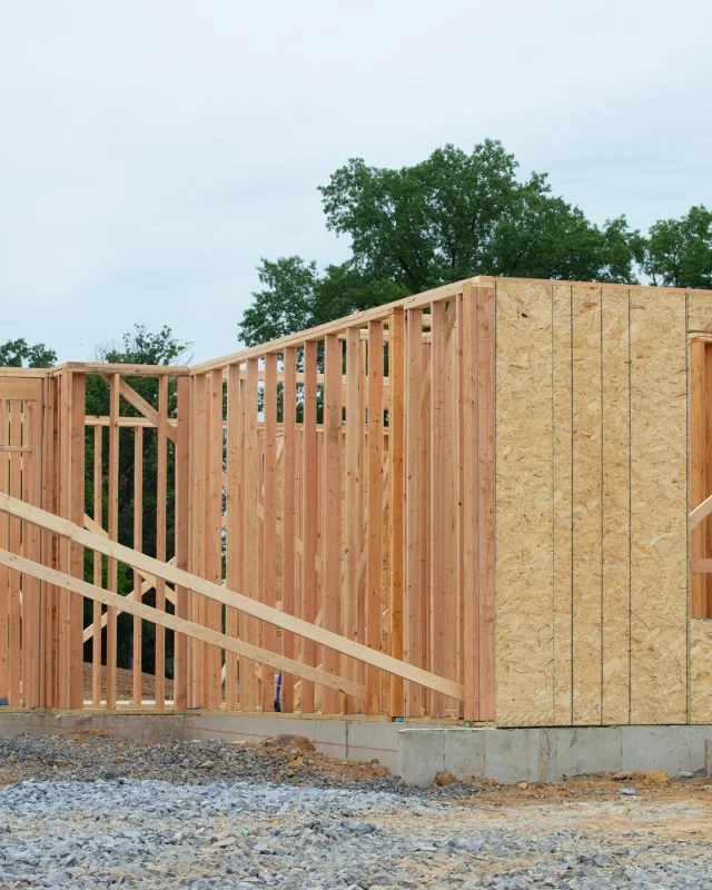 Timber-framed wall with sheathing standing on a new foundation