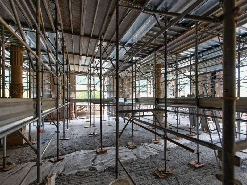 Scaffolding standing in an unfinished interior with the work stopped