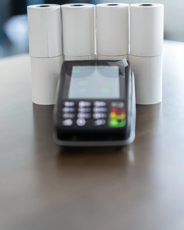 Retail checkout counter with a card payment terminal and a point of sale screen