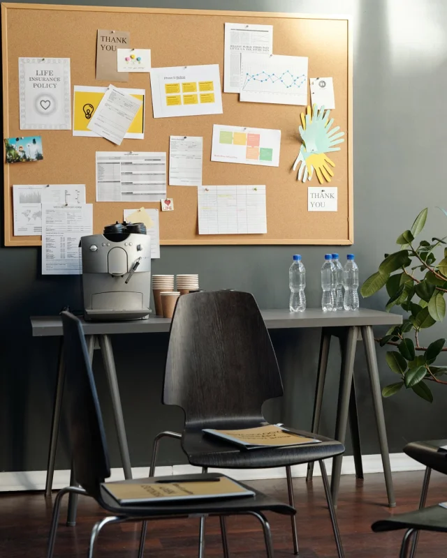 Community meeting room with a noticeboard and unoccupied chairs