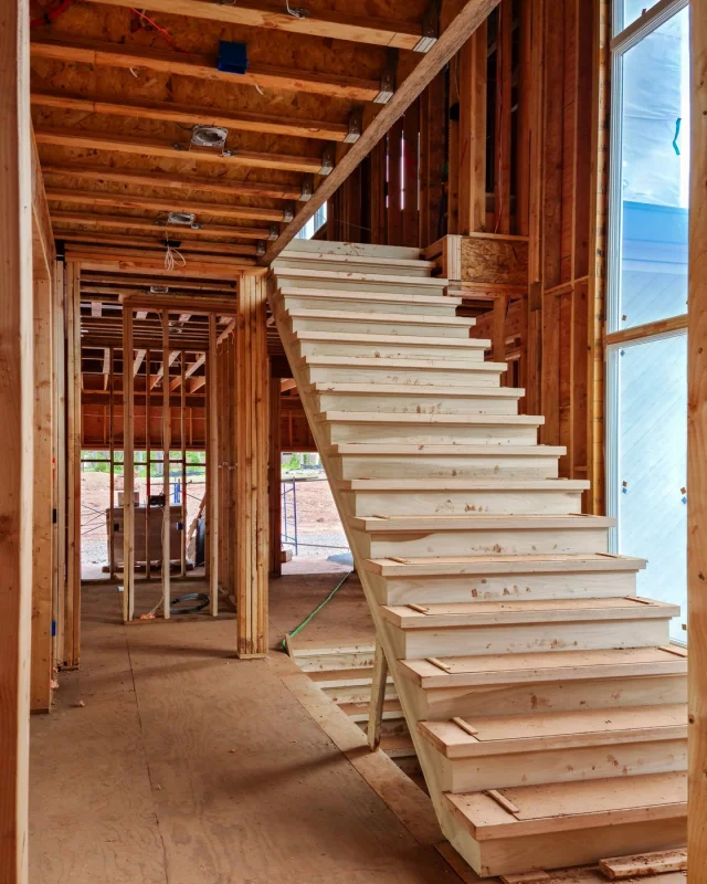 Stairs and open stud framing in a house under construction, before the walls are lined
