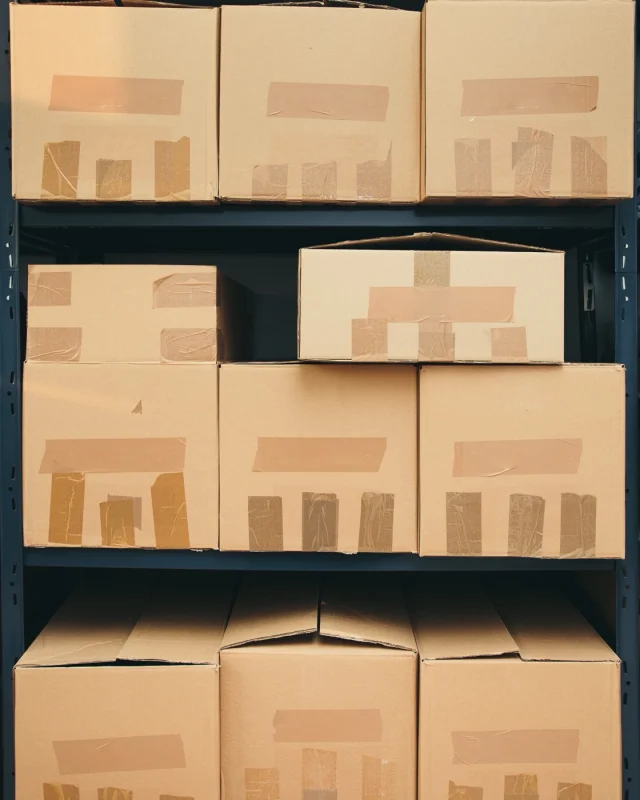 Cartons stacked on shelving in a stockroom aisle