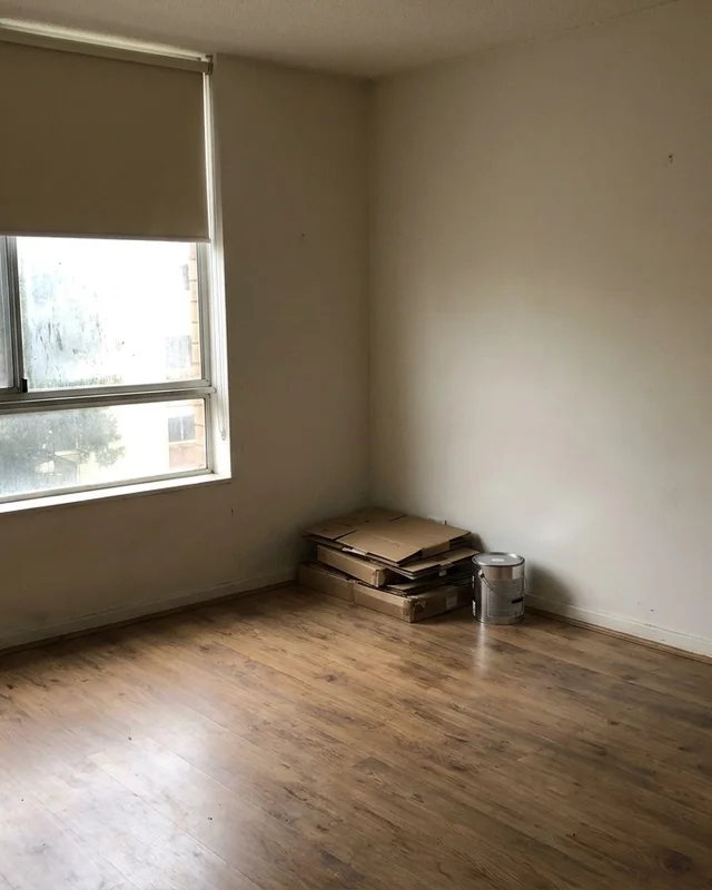 Empty rental apartment interior between tenancies with boxes stacked in the corner