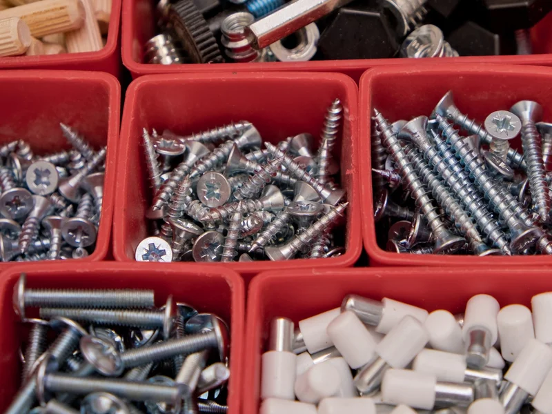 Sorted trays of screws, bolts and fittings on a workbench