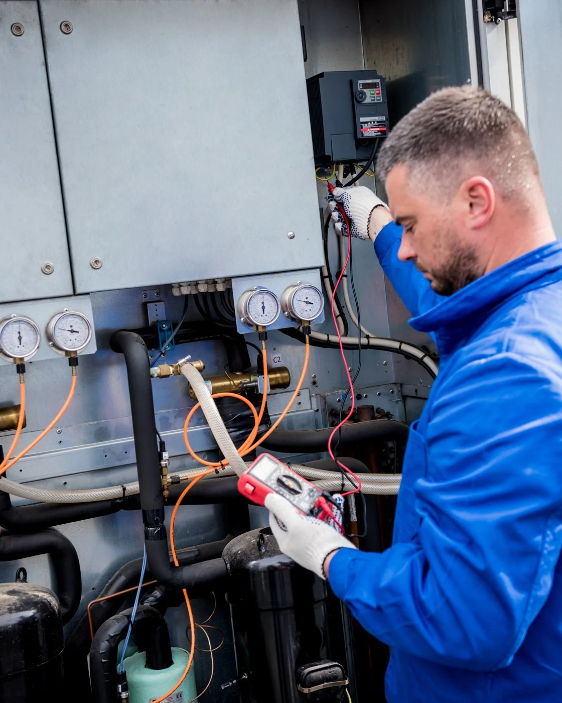 Technician testing temperature sensors in the cooling section of an air handling unit