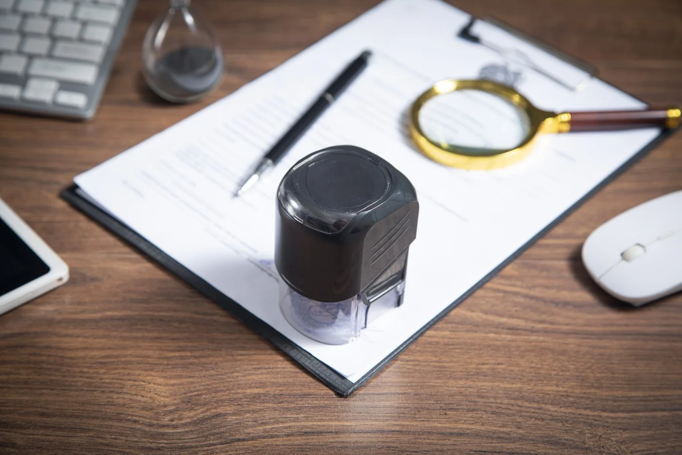 Stamped certificate on a clipboard with a pen and a magnifier