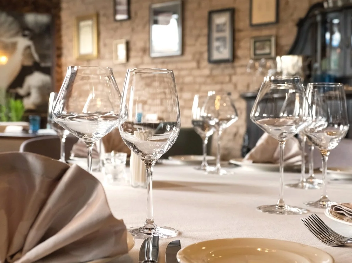 Wine glasses set on a table in an empty dining room
