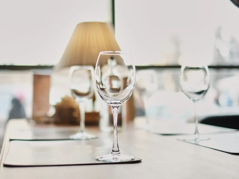 Clean wine glasses standing ready on a laid table