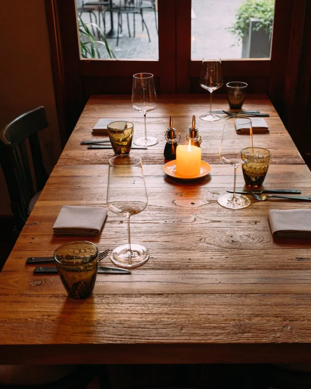 Set dining tables with wine glasses in an empty restaurant room