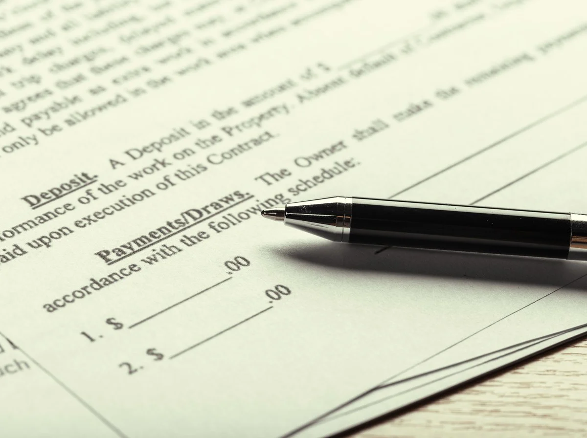 Open ring binder of project records on a desk beside a pen