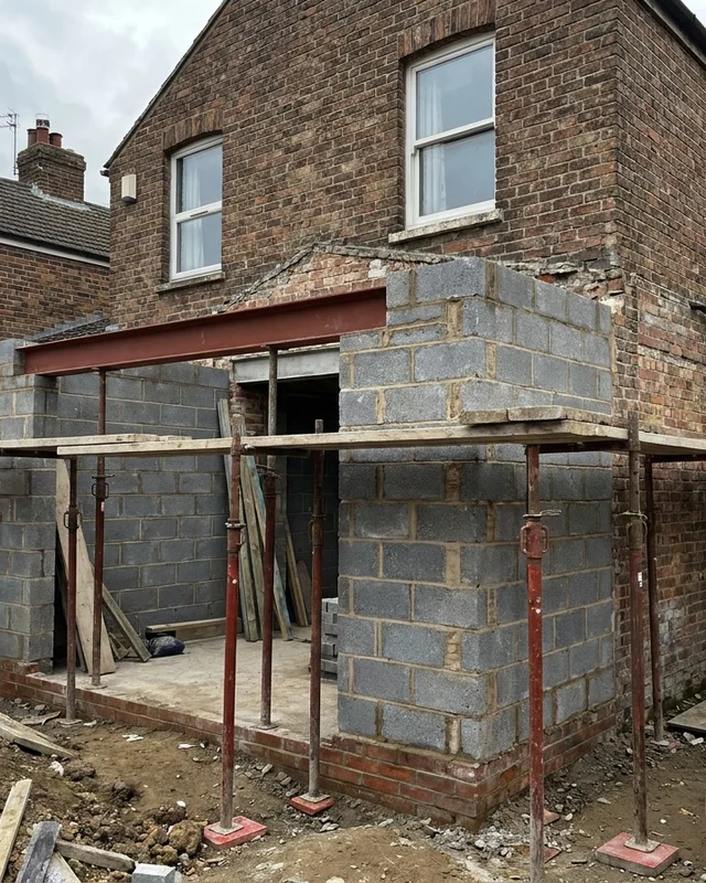 Rear extension under construction where new blockwork meets the existing brick wall