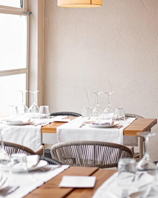 Empty restaurant dining room with tables set in white linen