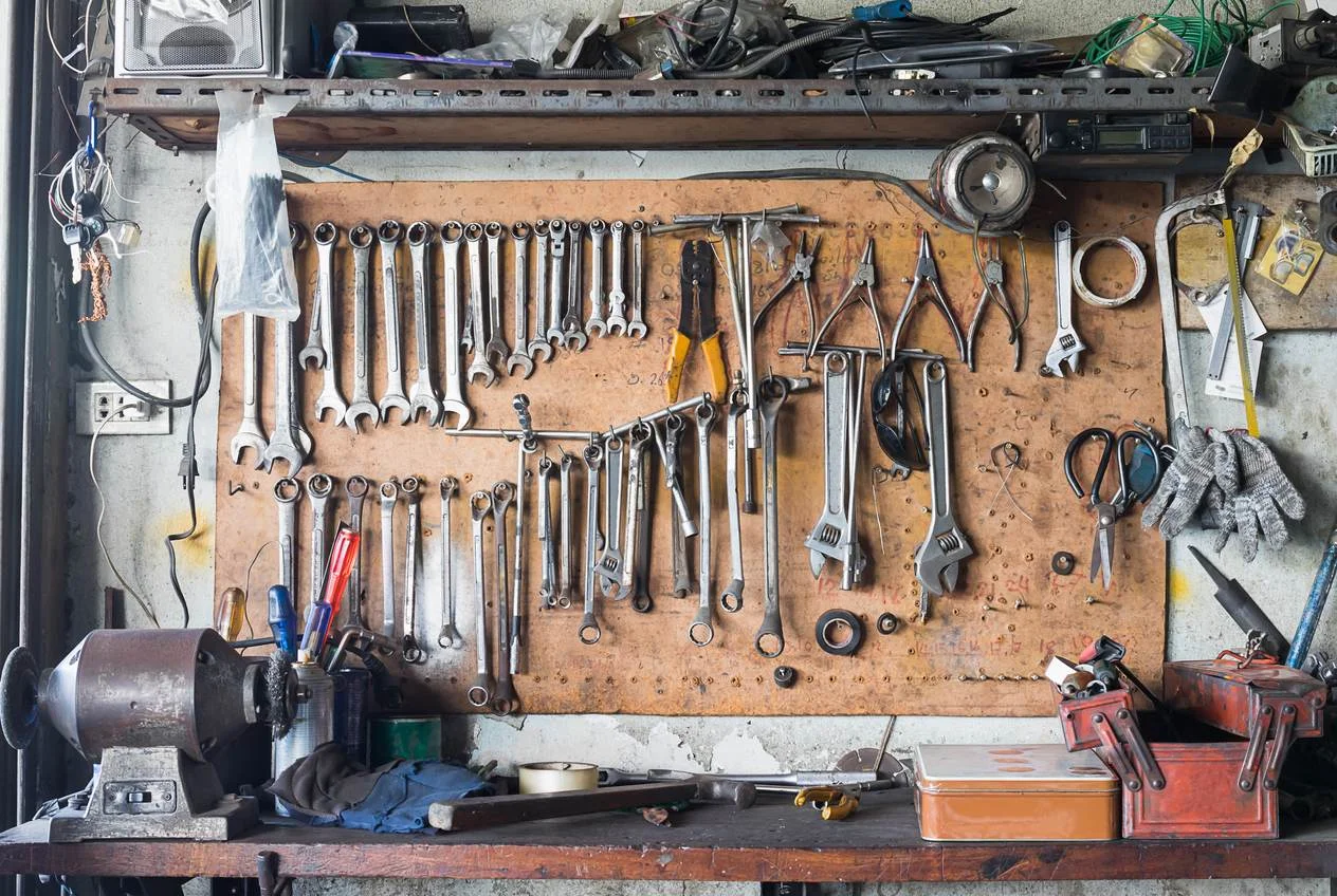 Racked tools and equipment inside a work van with the rear doors open