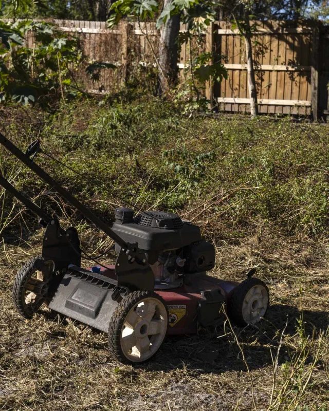 Ride-on mower and equipment trailer in a yard