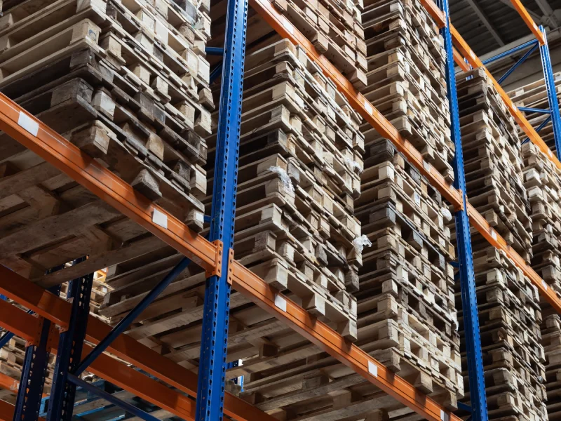 Wooden pallets stacked on steel racking in a distribution warehouse